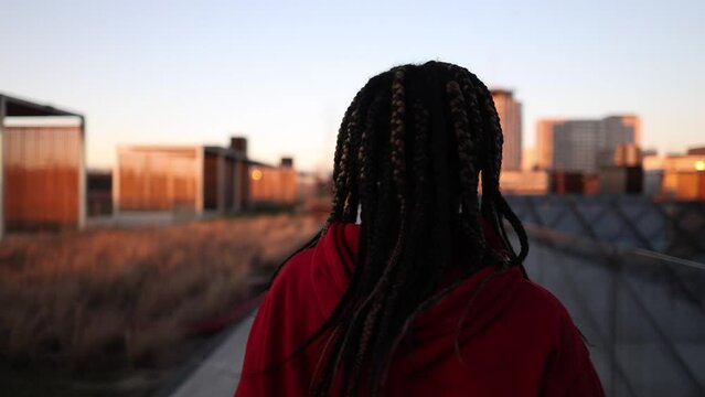 young african american woman running through the city background buildings at sunset - follow me -
