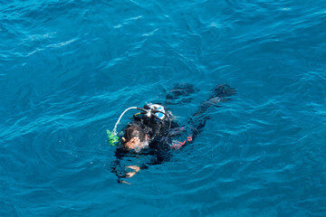 Diver with scuba swimming in Red sea blue water, Egypt