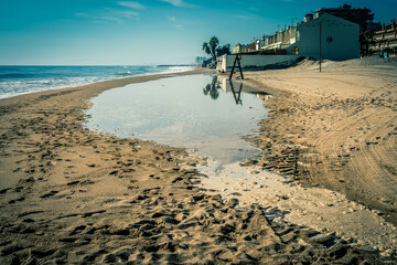 Playa de arena con pequeño charco