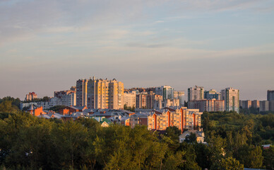 Panoramic top view of the modern houses of the residential area of the city of Vladimir in Russia and a park with lush green foliage of trees on a sunny summer morning