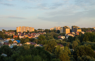 Fototapeta na wymiar Panoramic top view of the modern houses of the residential area of the city of Vladimir in Russia and a park with lush green foliage of trees on a sunny summer morning