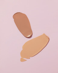 Makeup foundation, beige concealer swatch smudge smear on pink background. BB CC cream texture.