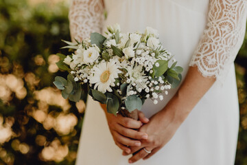 Future mariée tenant son bouquet de fleurs dans les mains