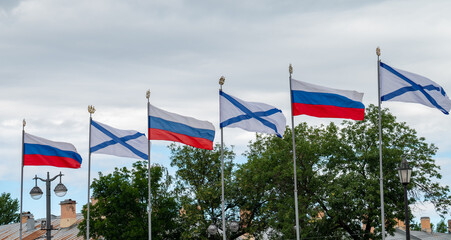 Flagpoles with Russian and St. Andrew's flags on the embankment in St. Petersburg