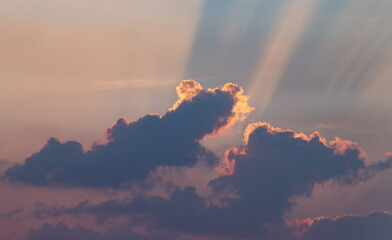 Fototapeta na wymiar The rays of the setting sun break through the clouds. Sunset