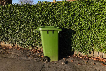 Naklejka premium Copenhagen, Denmark A green garbage can on a street in the Amager district.