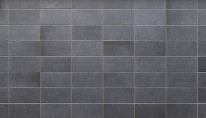 Front view of a wall made of gray slabs. Abstract full frame background of a new and modern wall or building exterior made of grey slabs.