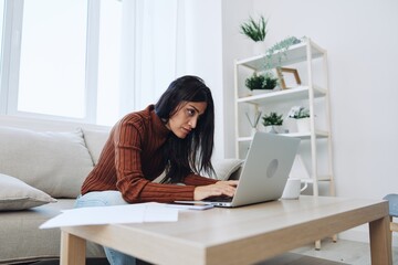 Sad freelance woman typing on laptop and working online from home