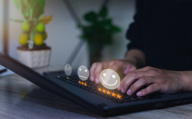 Businessman pressing emoticon face on laptop keyboard / customer service appraisal concept