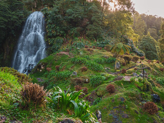 Waterfall surrounded by lush green pasture on San Miguel island in the Azores Portugal. 