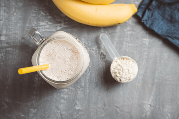 Banana smoothie with protein powder in a glass jar, top view, healthy eating concept
