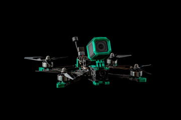Modern FPV drone. Four-engine aircraft on the radio control. Drone for racing, filming and entertainment. Dark back.
