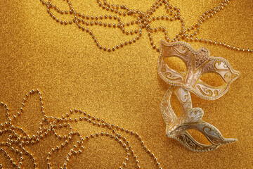 Fototapeta na wymiar Mardi gras or carnival mask with beads on gold glowing background. Venetian mask.