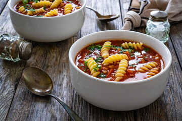 Tomato soup with noodles on wooden table
