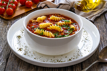 Tomato soup with noodles on wooden table

