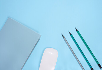 Blue notepad and wooden pencil on a blue background,