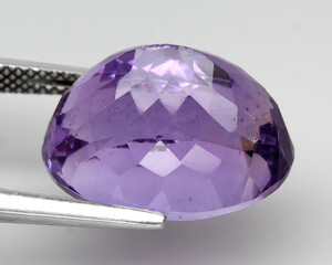 Natural gemstone purple amethyst on gray background