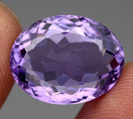 Natural gemstone purple amethyst on gray background