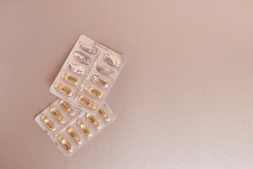 Vitamins in the form of capsules on a silver background. Treatment and prevention of diseases. Strengthening immunity.