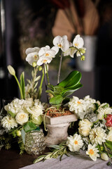 Arreglo floral para boda con orquideas, dhalias, rosas, hortensias y proteas en base de concreto 