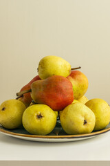 A bunch of delicious ripe pears on a porcelain plate