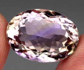 Natural gemstone bicolor ametrine on a gray background