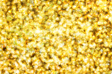 Golden shiny background. Abstract vibrant color glowing white spots texture for graphic design. Bright yellow defocused glitter texture. Festive background. Party texture.	