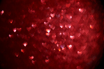 Bokeh background in the form of bright and shiny red hearts. A conceptual template for a Valentine's Day greeting card, banner, poster.
