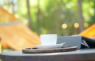 Hot coffee in human hands. Coffee foam flowers in a white cup. gray wood background
