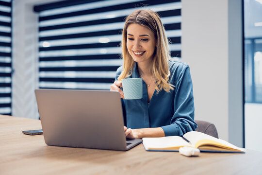 Businesswoman taking break and drinking coffee in office