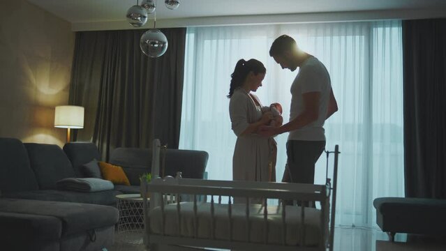 Young parents taking care of their baby. An attractive young couple embracing each other while holding their baby girl in slow-motion