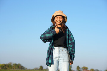 Asian female farmer uses computer to analyze rice growth.