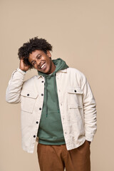 Fototapeta premium Happy young African American gen z guy isolated on beige background. Smiling hipster ethnic teen student, cool curly ethnic generation z teenager fashion model standing laughing, vertical shot.