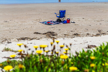 A single empty chair on a sandy beach