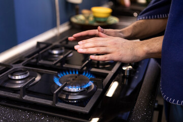 Close-up photo of freezing male hands warming close to gas oven. Cold winter and high price taxes concept