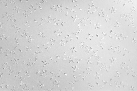white paper background with embossed flowers, copy space, textured floral pattern