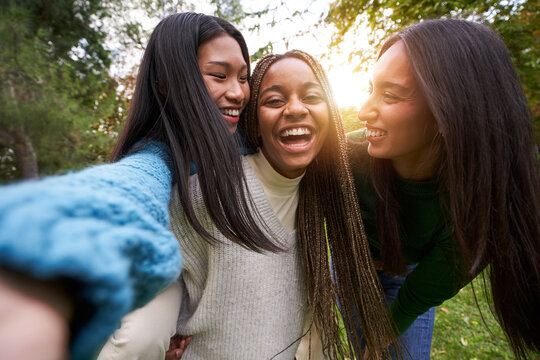 Portrait Of Three Girls Outside Having Fun Taking Selfie. An Asian Chinese Woman, A Black African American And A Caucasian Lady Together And Embracing. Friendship In Multi-ethnic Groups Of People