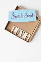 short & sweet and the word "love" inside a square paper box