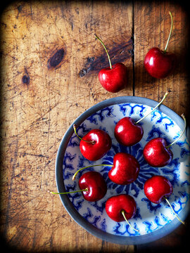 Overhead view of cherries on wooden table