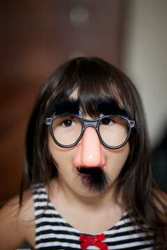 A young Asian girl in a silly mask.