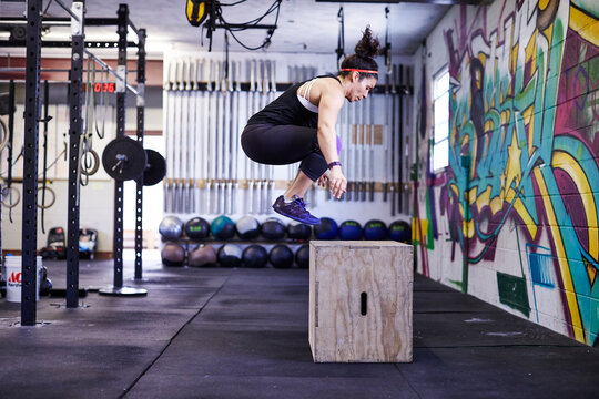 A female athlete trains in a crossfit gym.