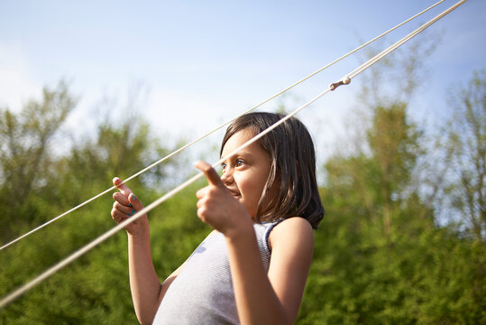 Young Asian Girl Playing With Tent Lines In Summer Sunshine