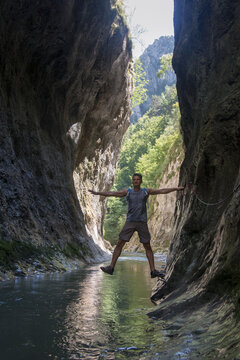 Adult male crossing Ramet gorge, river passing through the rocks