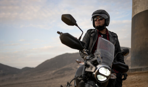 Latin man motorcyclist look at distance.