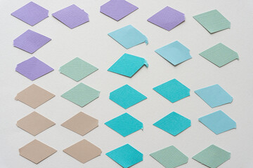 cut paper shapes (squares or diamonds) in various shades of purple and blue on blank paper