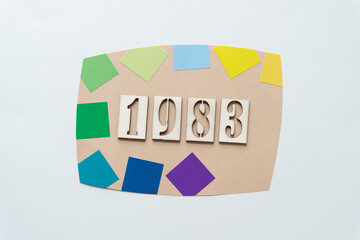 decorative sign with the year 1983 and colorful sticker squares