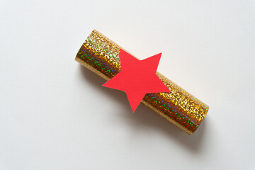 red star on gold foil glitter paper tube on blank paper