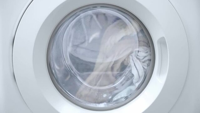 Washing clothes process. Washing machine working with laundry, close up