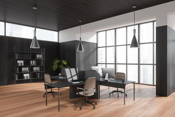 Corner view on dark office room interior with computers, desks