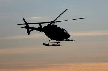 Fototapeta na wymiar Helicopter silhouette in mid air at dusk